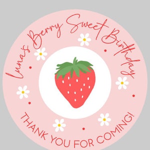 K&ouml;nnte beinhalten: Ein runder Aufkleber mit hellrosa Hintergrund und einer roten Erdbeerillustration in der Mitte. Der Text "Luna's Berry Sweet Birthday" und "Thank you for coming!" sind in roter Schrift um die Erdbeere geschrieben, mit kleinen wei&szlig;en G&auml;nsebl&uuml;mchen-Illustrationen.