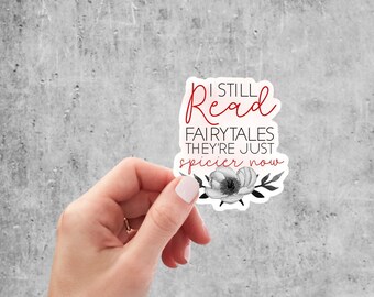 May include: A white sticker with a black and white floral design. The sticker says "I still read fairytales they're just spicier now" in red text.