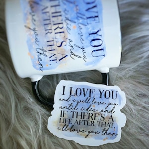 May include: A white ceramic mug with a blue watercolor design and the text "I love you and I will love you until I die and if there's a life after that, I'll love you then." A sticker with the same text and design is shown on a fuzzy surface.