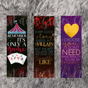 May include: Three bookmarks with different designs and quotes. The first bookmark has a black background with a red, white, and blue circus tent, playing cards, and the text "Remember, it's only a game". The second bookmark has a red background with gold glitter and the text "Every good story needs a villain, but the best villains are the ones you secretly like". The third bookmark has a purple background with a gold heart and the text "I choose you, I don't need immortality, you're my forever".