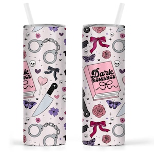 May include: A light pink tumbler with a white straw, featuring a repeating pattern of handcuffs, knives, butterflies, roses, and the text "Dark Romance" on a book. The design includes black, purple, and pink elements.