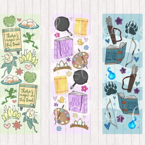 Può includere: Tre design di segnalibri colorati con temi diversi. Il primo segnalibro è verde e presenta una rana, una corona e il testo "There's magic in this book". Il secondo segnalibro è viola e presenta una tavolozza di colori, una corona e il testo "Just Book It". Il terzo segnalibro è blu e presenta un arco e frecce, un'impronta di zampa e il testo "This Book Will Change Your Fate".