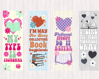 May include: Four colorful bookmarks with book-themed designs. The first bookmark features a pink heart with a book inside and the text "My Type Is Fictional". The second bookmark features a red heart with the text "I'm Way Too Busy Collecting Book Boyfriends". The third bookmark features a purple heart with a book inside and the text "Fictional Men Do It Better". The fourth bookmark features a gray heart with a book inside and the text "I Like My Men Morally Gray".