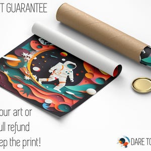 May include: A colorful, abstract art print featuring an astronaut walking on a swirling, multi-colored planet. The print has a paper-cut style and is rolled up in a brown tube. The text "LOVE-IT GUARANTEE" is at the top of the image. The text "Love your art or get a full refund...& keep the print!" is at the bottom of the image. The text "DARE TO DREAM" is at the bottom right corner of the image.