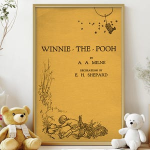May include: A framed print of the book cover for "Winnie-the-Pooh" by A.A. Milne, with illustrations by E.H. Shepard. The cover is a mustard yellow color with black text and illustrations. A teddy bear and other toys are in the foreground.