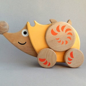 A toy made of wood is a hedgehog, for children, a toy on wheels, animal, alder, toys, wood products, a children's toy, a gift for a child