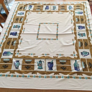 May include: White tablecloth with a brown and blue border featuring a repeating pattern of jars and bottles with labels that say "Curry", "Spices", and "Thyme".