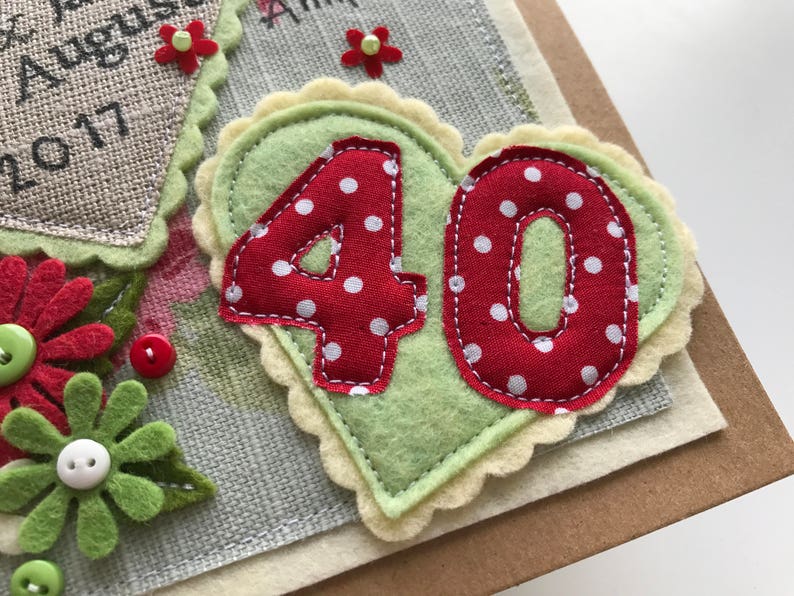 May include: Handmade birthday card with a felt heart featuring the number "40" in red polka dot fabric. The heart is on a light green background with a scalloped edge. Additional floral and button embellishments.