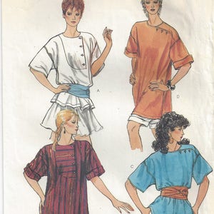 May include: Vogue Patterns sewing pattern featuring four different women's tops and dresses. The pattern includes a white dress with a ruffled skirt, an orange tunic, a striped dress, and a blue top. The pattern is labeled "TAILLE PETITE SIZE SMALL".
