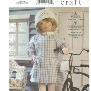 Op de afbeelding: Vogue Craft patroon 7513 voor een pop. De pop draagt een blauw-wit geruite jurk, een witte hoed en een kleine handtas. De pop staat naast een vintage fiets. Het patroon bevat een full colour strijktransfer voor het gezicht.