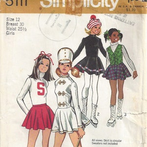 May include: A vintage sewing pattern for girls' costumes. The pattern includes three different looks: a cheerleader outfit with a red skirt and white sweater, a marching band uniform with a white skirt and a white jacket with gold buttons, and a skater dress with a black skirt and white tights. The pattern is from Simplicity and is size 12, with a 76 cm bust and a 65 cm waist.