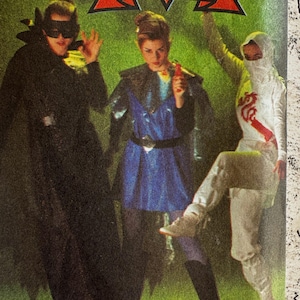 Puede incluir: Imagen de un patrón de costura con tres disfraces: una capa y máscara negras, un atuendo azul con capa y un disfraz blanco estilo ninja. El texto "JUST FUSE 'N' GO" se muestra en la parte superior.