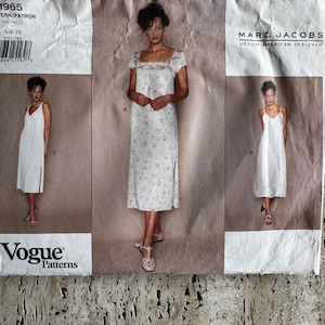 May include: A Vogue Patterns sewing pattern designed by Marc Jacobs. The pattern offers dress designs with different necklines and shapes. The pattern envelope is white with black text and images of the finished dresses.