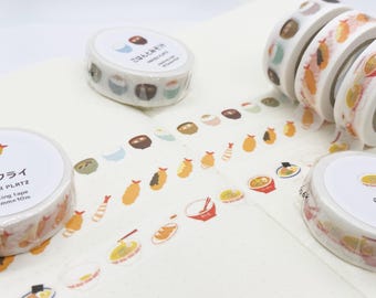Op de afbeelding: Verschillende rollen washi-tape met illustraties van Japans eten, waaronder sushi, tempura en ramen. De tape is wit met kleurrijke voedselontwerpen en tekst. De tape is 1,5 cm breed en 10 m lang.