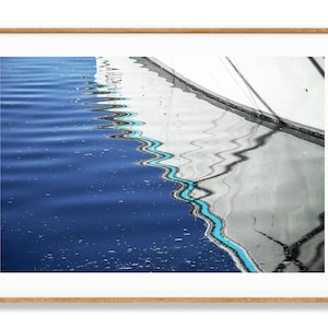 May include: Abstract photograph of a blue and white water reflection with a turquoise line running through the center.