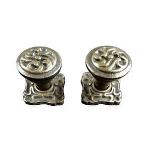 Può includere: Due pomelli per mobili antichi in bronzo. Ogni pomello presenta un motivo decorativo a spirale sulla testa rotonda e una base ornata. Adatti per mobili o armadi, aggiungendo un tocco vintage.