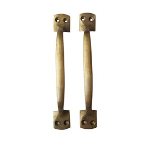 May include: Two antique brass door handles with a simple design. Each handle has a rectangular plate with two holes and a long, straight handle.