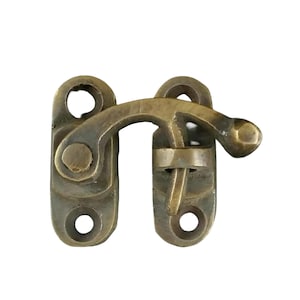 May include: Brass latch with a hook and two holes. The latch is in a closed position.
