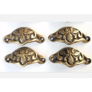 May include: Four antique brass drawer pulls with a floral design. Each pull has two holes for mounting.