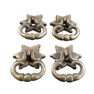 May include: Four antique brass cabinet drawer pulls with a decorative floral design. Each pull has a ring-shaped handle.