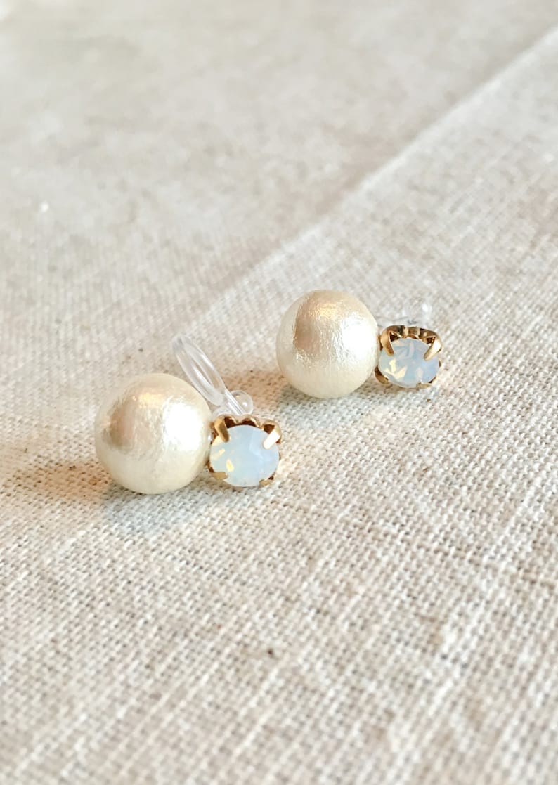 May include: A pair of pearl and rhinestone clip-on earrings. The earrings feature a white pearl and a clear rhinestone.