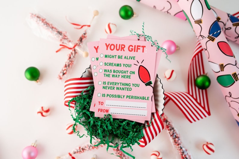 May include: Pink gift tags with a red lightbulb graphic and the text "Your Gift" and a checklist of humorous gift descriptions. The text includes "Might be alive", "Screams you!" and "Is possibly perishable".