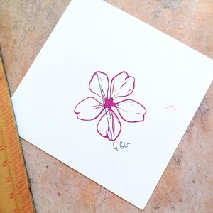 Pode incluir: Uma flor rosa com cinco p&eacute;talas est&aacute; impressa em um peda&ccedil;o de papel branco. Uma r&eacute;gua &eacute; vis&iacute;vel no fundo. A flor tem 4,6 cm de largura.