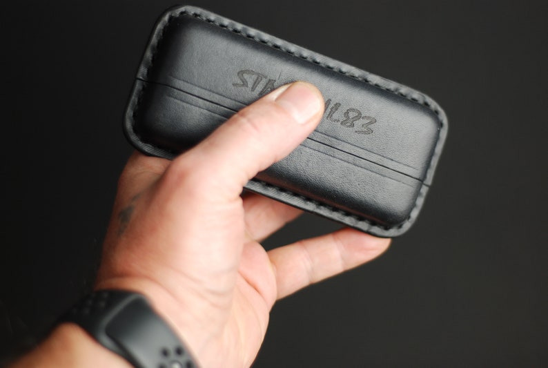 Puede incluir: Una funda de cuero negro con el texto "STAHL 1883" grabado en la parte delantera.