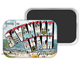 May include: A rectangular magnet featuring a vintage postcard design. The magnet reads "Greetings from SAVANNAH BEACH Georgia" in a 3D style with red and white lettering. The postcard image depicts a beach scene with people, palm trees, and a lighthouse.