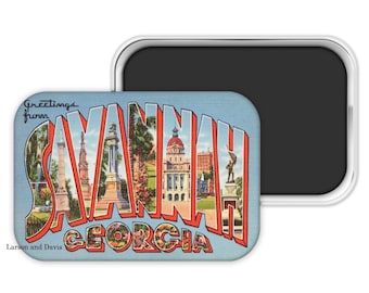 May include: A rectangular magnet with a retro postcard design. The magnet features the words "Greetings from SAVANNAH GEORGIA" in a stylized font, with images of landmarks within the letters. The magnet has a silver border and a black magnetic backing.