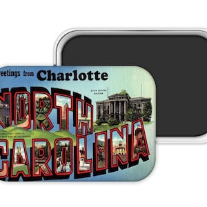 May include: A rectangular magnet featuring a vintage postcard design. The magnet reads "Greetings from Charlotte, North Carolina" in bold, stylized lettering. The design includes images of landmarks and scenery, with a blue and red color scheme.