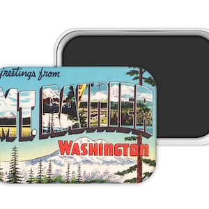 May include: A rectangular magnet with a vintage postcard design. The magnet features the text "Greetings from Mt. Rainier Washington" in a stylized font. The image within the letters depicts a mountain landscape with trees and a lake. The magnet has a silver border.