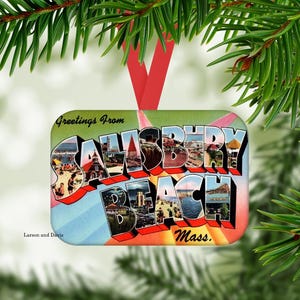 May include: A rectangular Christmas ornament featuring a vintage-style postcard design with the text Greetings From Salisbury Beach Mass. The graphic includes colorful scenes of the beach and boardwalk inside the large block lettering.