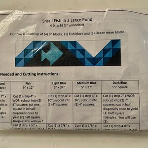 May include: A quilting pattern for a "Small Fish in a Large Pond" quilt. The pattern includes instructions for cutting fabric strips in various colors, including white, light blue, medium blue, and dark blue, to create a fish design. The finished quilt will measure 9 1/2 inches by 36 1/2 inches.