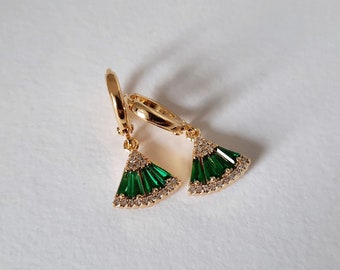 May include: A pair of gold hoop earrings with green and clear crystal accents. The earrings have a fan-shaped design.