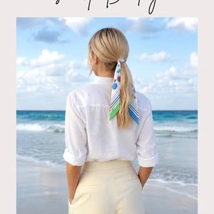 May include: A mini silk twill scarf featuring a multicolored pattern of circles and stripes in shades of blue, green, pink, and yellow. The scarf is shown tied around a wrist, styled as a hair tie on a ponytail, and worn as a neckerchief.