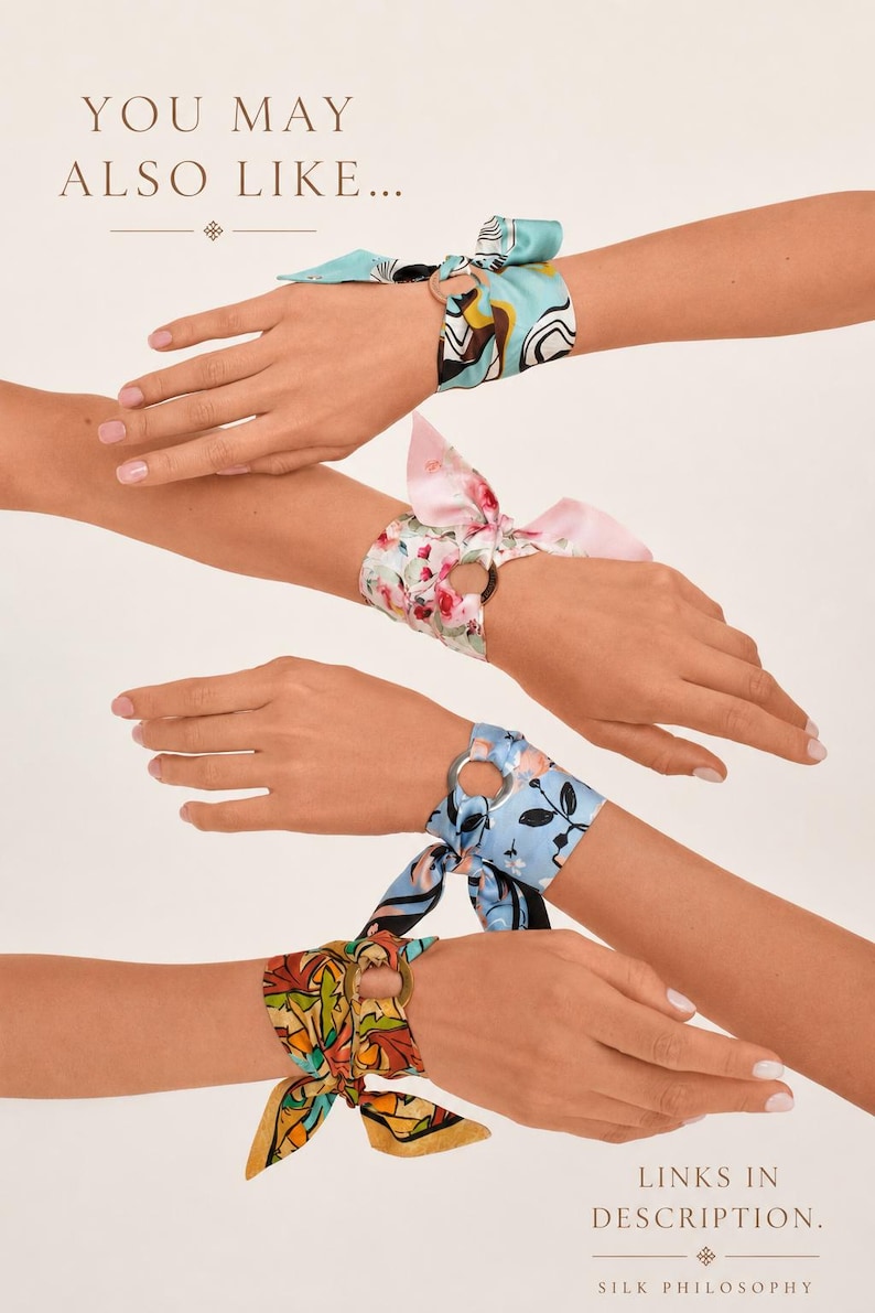 May include: Four silk wrist scarves tied through circular metal rings. The scarves feature various patterns including abstract blue and yellow shapes, pink floral prints, light blue floral designs, and multicolored autumn leaf motifs.