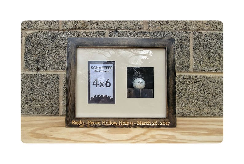 Puede incluir: Un marco de fotos de madera de doble apertura con acabado marr&oacute;n oscuro. Un lado muestra una impresi&oacute;n de 4x6, el otro una pelota de golf. El marco est&aacute; inscrito con "Eagle - Pecan Hollow Hole 9 - March 26, 2017".