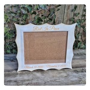 May include: White wooden picture frame with a scalloped edge. The frame has a brown cardboard insert and the text "Rest In Peace" and "March 10 1980 - November 3 2010" is engraved in gold.