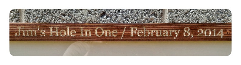 May include: A wooden plaque with the inscription "Jim's Hole In One / February 8, 2014".
