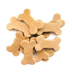 May include: A pile of light brown dog biscuits shaped like bones.