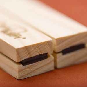 May include: Two wooden blocks with a black magnet strip on each side. The blocks are joined together.