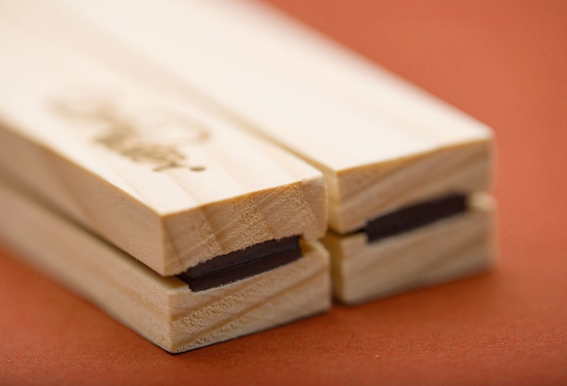 May include: Two wooden blocks with a black magnet strip on each side. The blocks are joined together.