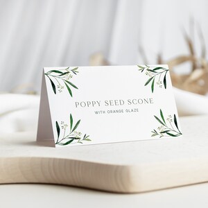 May include: A white card with green floral accents and the text "Poppy Seed Scone with Orange Glaze".