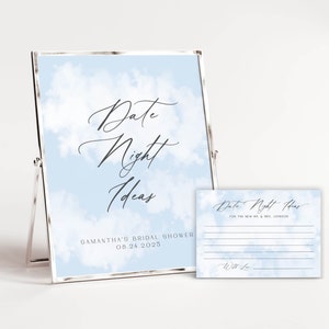 May include: A blue and white card with a cloud background and the text "Date Night Ideas" with a line for writing. The card is in a silver frame and there is a smaller card with the same design and the text "Date Night Ideas for the new Mr. & Mrs. Johnson" with lines for writing.