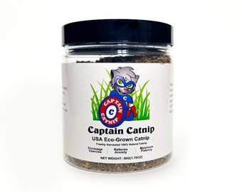 May include: A clear glass jar with a black lid filled with dried catnip. The label features a cartoon cat superhero with a red, white, and blue costume. The label reads "Captain Catnip USA Eco-Grown Catnip Freshly Harvested 100% Natural Catnip Encouage Exercise Relieves Anxiety Maximum Potency NET WEIGHT: 50G(1.76OZ)"