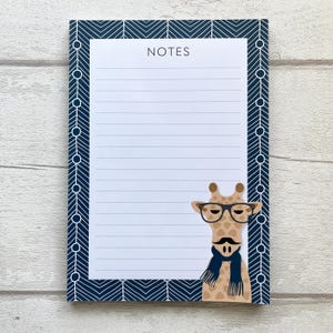 May include: A blue notepad with a white chevron pattern border. The notepad has a lined interior and the word "NOTES" printed at the top. A cartoon giraffe with glasses and a scarf is on the right side of the notepad.