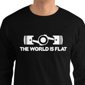 May include: Black long-sleeve t-shirt with a white graphic of two pistons connected by a crankshaft. The text "THE WORLD IS FLAT" is printed below the graphic.