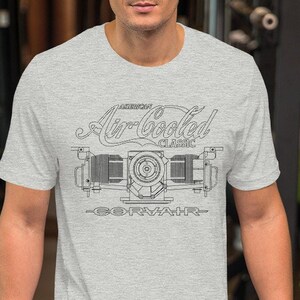 Könnte beinhalten: Ein heidefarbenes T-Shirt mit einer schwarz-weißen Illustration eines luftgekühlten Motors. Der Text "American Air-Cooled Classic Corvair" ist auf dem T-Shirt aufgedruckt.