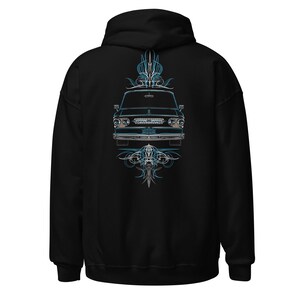 Könnte beinhalten: Schwarzer Kapuzenpullover mit einer detaillierten Illustration eines klassischen Autos. Das Auto befindet sich in der Mitte mit blauen und weißen Nadelstreifen. Das Design ist symmetrisch, mit dem Bild des Autos oben und unten gespiegelt.